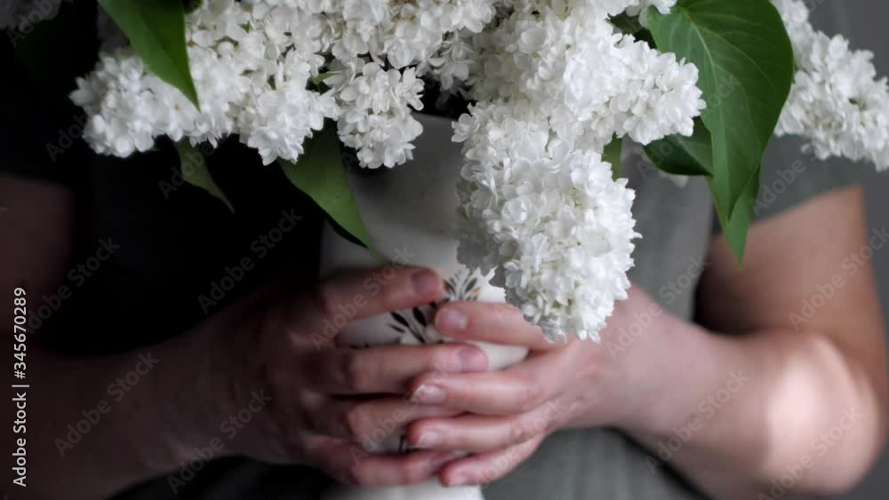 woman hands holding vase of white flowers woman hands holding vase of white flowers