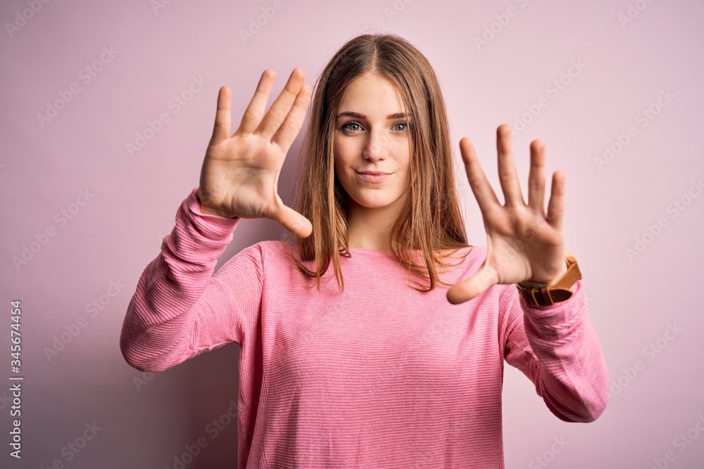 Young beautiful redhead woman wearing casual sweater over isolated pink background doing frame using hands palms and fingers, camera perspective Young beautiful redhead woman wearing casual sweater over isolated pink background doing frame using hands palms and fingers, camera perspective