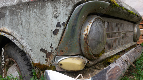 abandoned retro car overgrown with moss. wheels overgrown in the ground. cemetery of cars. Muscovite.