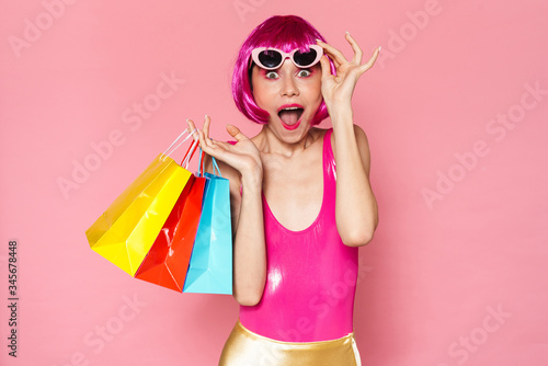 Image of excited girl screaming and holding shopping bags