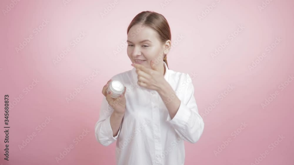 Beautiful girl with natural beauty puts white cream on her face and cheek. Beautiful girl with natural beauty puts white cream on her face and cheek.