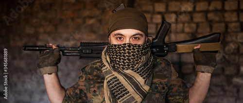 Arab male soldier in a headdress from the national keffiyeh with weapons in his hands. Muslim with firearms