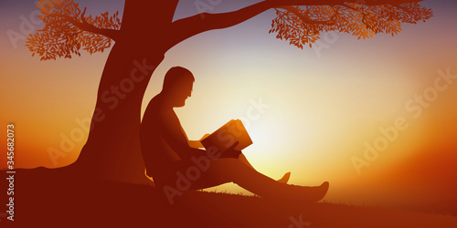 Concept d’un moment de détente avec un homme qui profite d’un moment de solitude et de tranquilité pour lire un livre au pied d’un arbre.