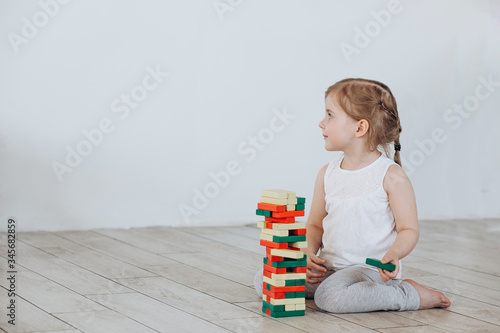 Little girl plays at home. A three-year-old child builds a pyramid.