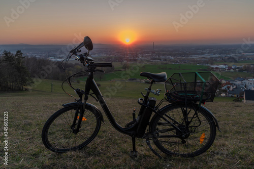 Black electric bike on ski slope in Budweis city with sunset