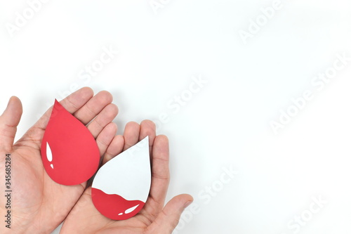 Obraz na płótnie Male hands holding blood drop. Donation and transfusion concept. World Blood Donor Day. w salonie