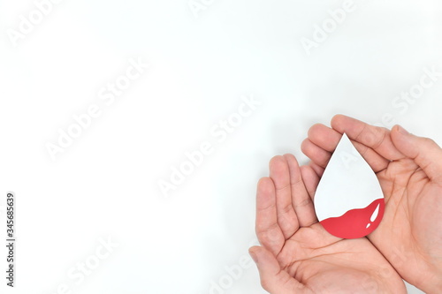 Anemia, low blood level, world blood donor day concept. Hands holding blood drop. photo