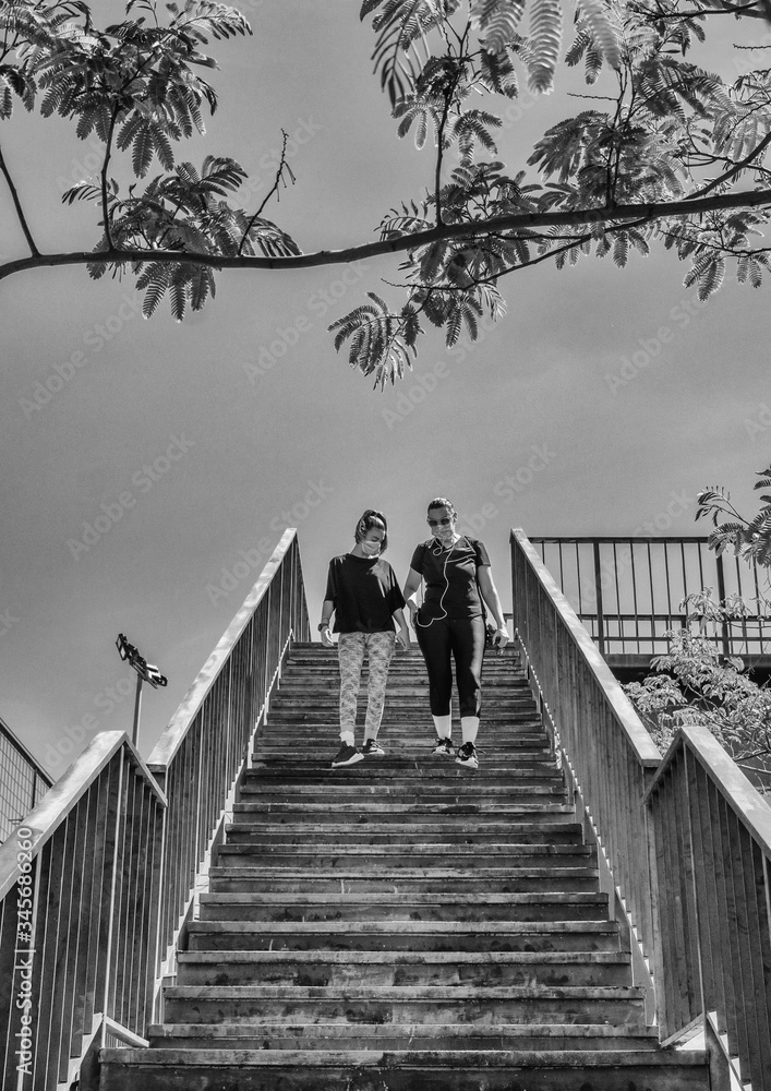 Obraz premium The Mother And Her 12-year-old Daughter Complying With The Schedules To Go For A Walk, Wearing A Mask Sanitary After The State Of Alarm. Covid-19 Bull Run Pandemic In Spain.