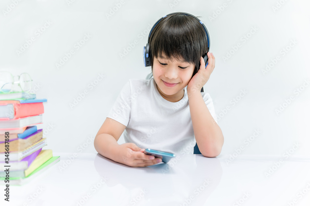 Happy child boy wear headphone and enjoy music by mobile phone Happy child boy wear headphone and enjoy music by mobile phone