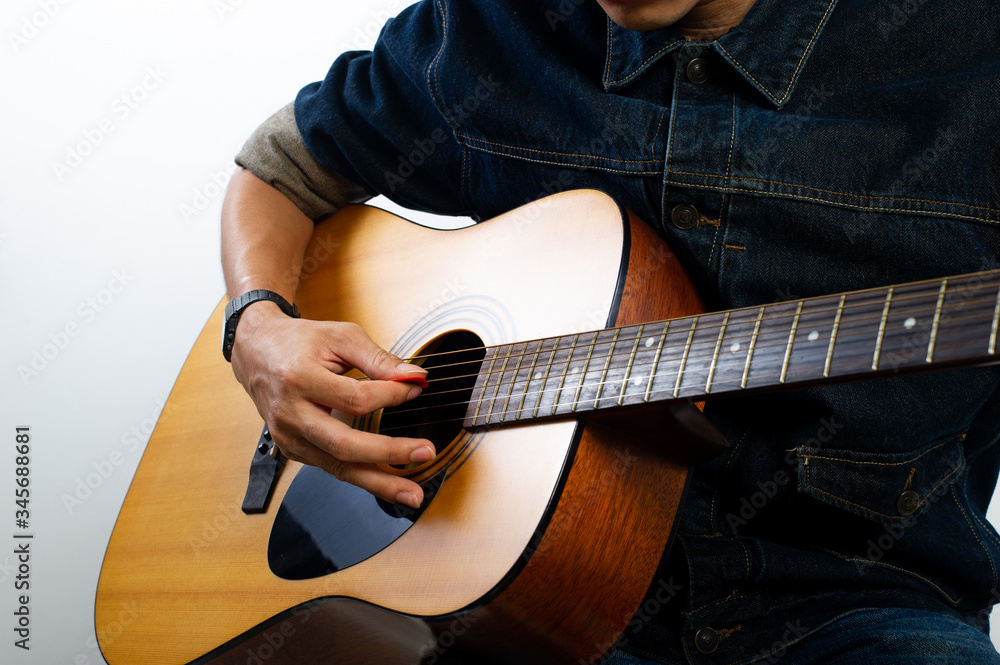 Fototapeta premium The acoustic guitarist is holding the guitar. And playing guitar Concepts of hobbies and relaxation in free time for good quality of life