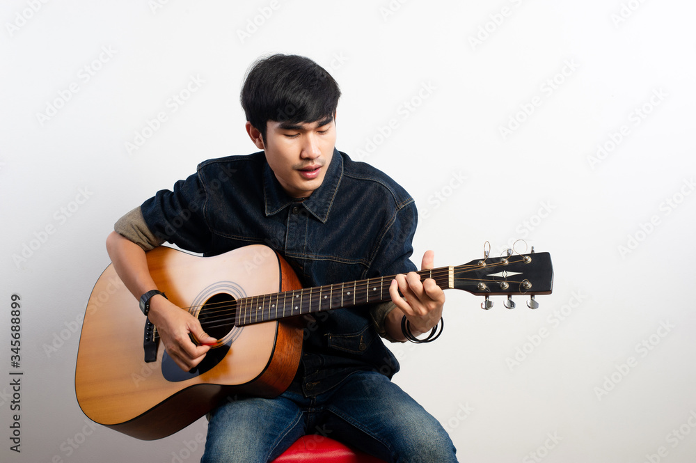 Obraz premium The acoustic guitarist is holding the guitar. And playing guitar Concepts of hobbies and relaxation in free time for good quality of life