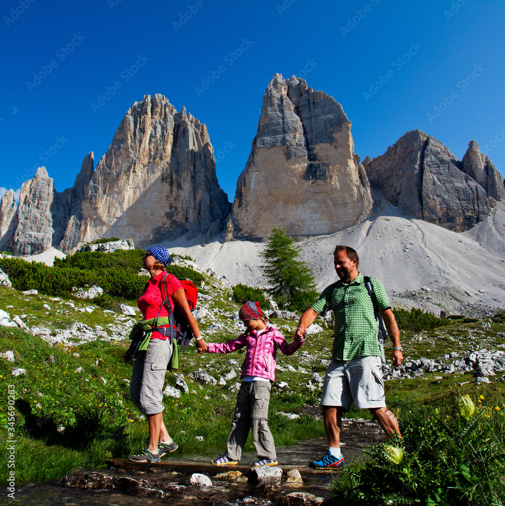 Happy family outdoor adventure with kid in Dolomites mountain in summer time in Italy. Concept of travel, friendly family.