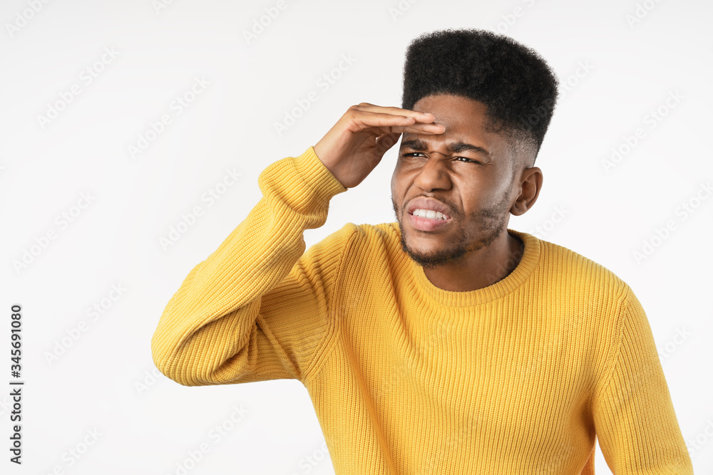 Young man looking far away with hand to look something over isolated white background Young man looking far away with hand to look something over isolated white background