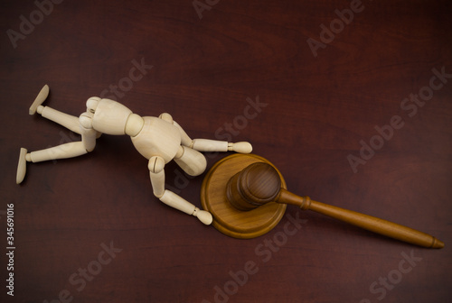 Worship of the law concept. Wooden mannequin and judge gavel.