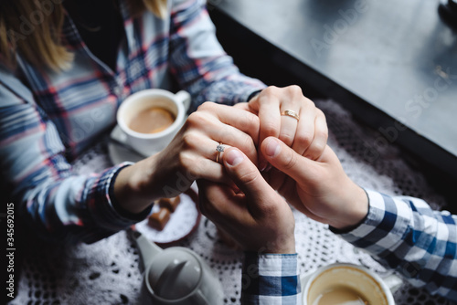 a couple holding each other's hands in the cafe