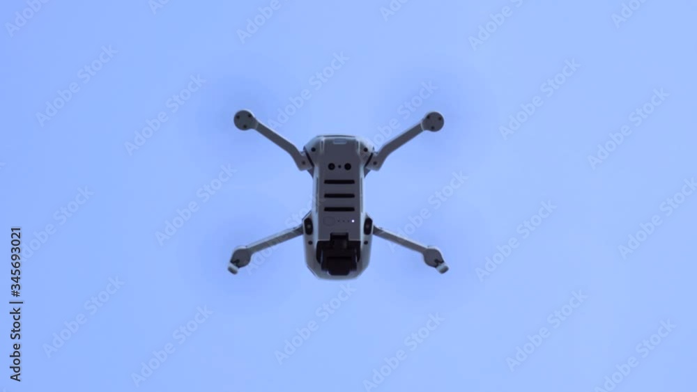 Gray drone flying in above, with rotating blades. Hanging in the air for sometimes, after go up and away. Gray drone flying in above, with rotating blades. Hanging in the air for sometimes, after go up and away.