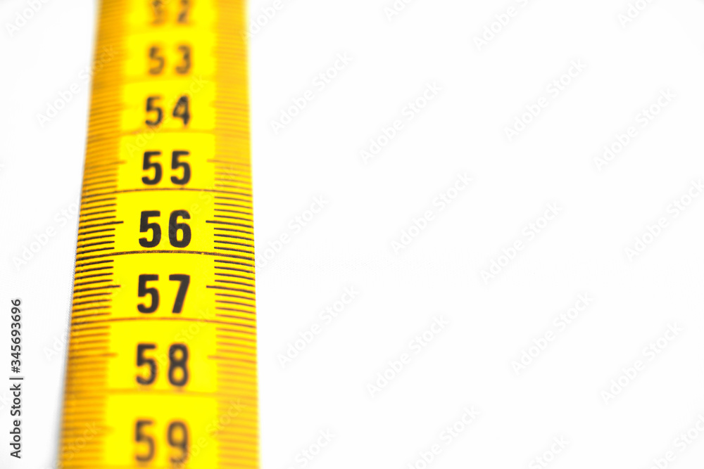 centimeter tape on a white background large frame. placement concept for the site of a sewing production workshop centimeter tape on a white background large frame. placement concept for the site of a sewing production workshop