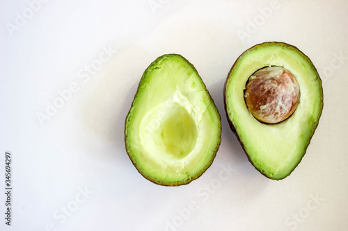 avocado cut in half on the white table on white background