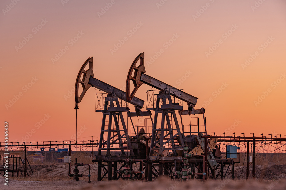 Oil pump rig. Oil and gas production. Oilfield site. Pump Jack are running. Drilling derricks for fossil fuels output and crude oil production. War on oil prices. Global coronavirus COVID 19 crisis. Oil pump rig. Oil and gas production. Oilfield site. Pump Jack are running. Drilling derricks for fossil fuels output and crude oil production. War on oil prices. Global coronavirus COVID 19 crisis.