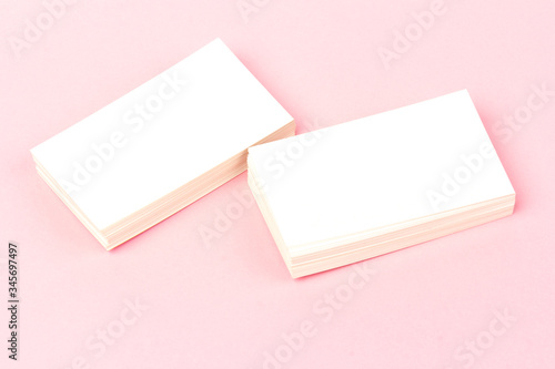 white blank business cards on pink background in close-up