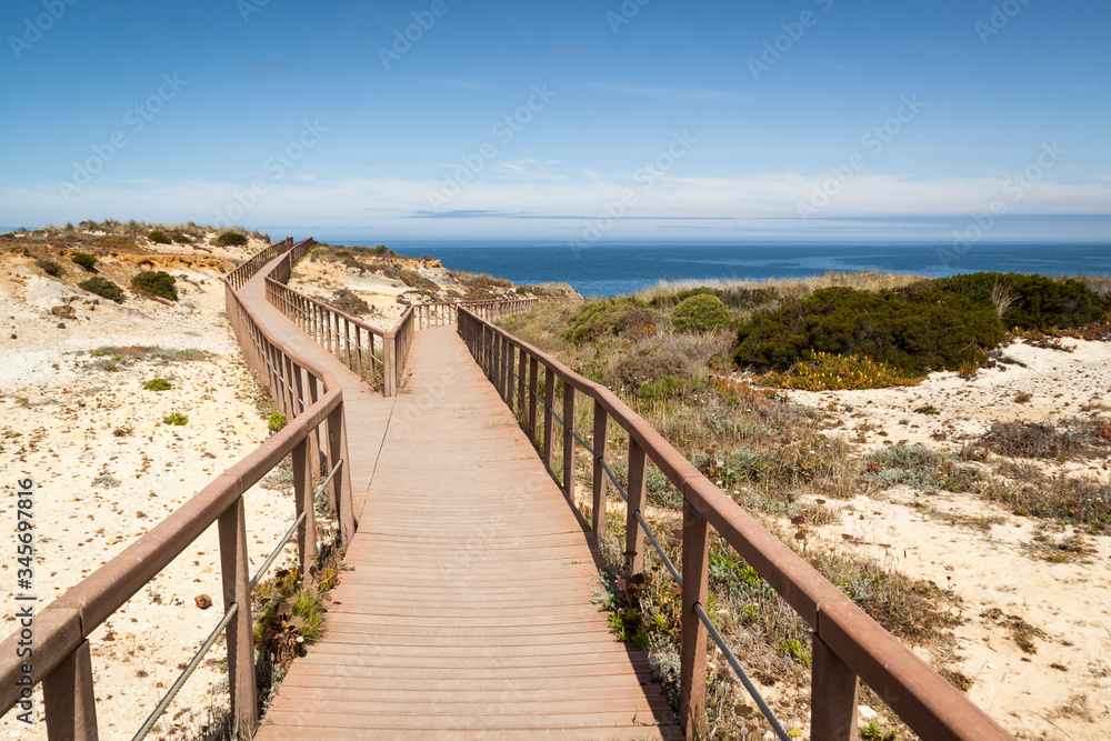 Fishermen's route in the Alentejo, promenade with cliffs in Portugal. Wooden walkway along the coastline. Fishermen's route in the Alentejo, promenade with cliffs in Portugal. Wooden walkway along the coastline.