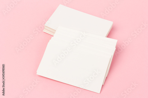 white blank business cards on pink background in close-up