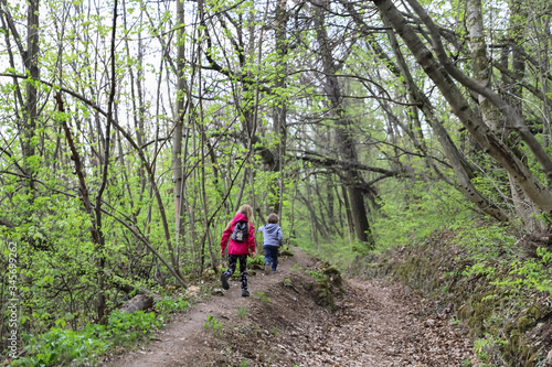 Boy and girl running or hike through the forest in early spring