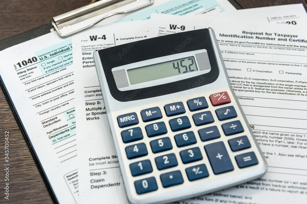 Finance income, time fot tax calculator and pen lying on federal form Finance income, time fot tax calculator and pen lying on federal form