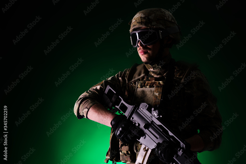 Soldier with gun is on mission on green background. Concept of war.