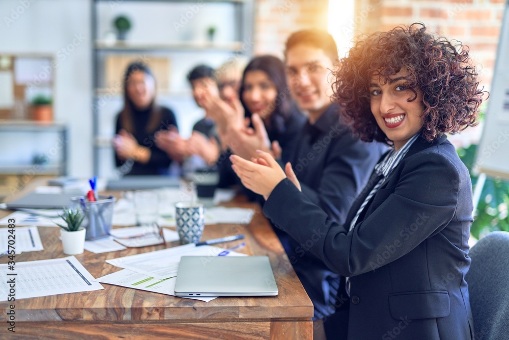 Group of business workers smiling happy and confident. Working together with smile on face looking at the camera applauding at the office Group of business workers smiling happy and confident. Working together with smile on face looking at the camera applauding at the office