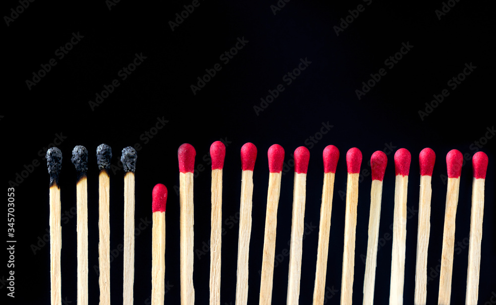 matchsticks burnt in row as sequence while one match stay down from burning to avoid fire connecting against black background, social stop pandemic concept. matchsticks burnt in row as sequence while one match stay down from burning to avoid fire connecting against black background, social stop pandemic concept.