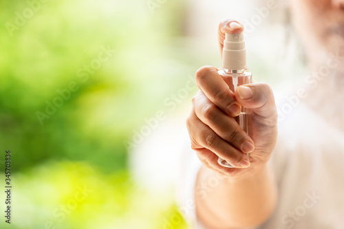 close-up Hand push on alocohol spray hand sanitizer bottle and spraying, disinfection for safety prevent and protect from infection of virus and germ Covid-19 coronavirus world pandemic. photo