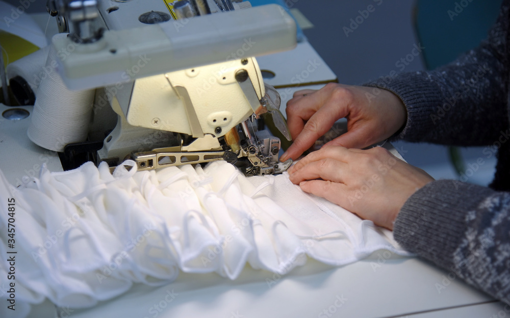 Worker sews protective gauze bandages, focus in the center.