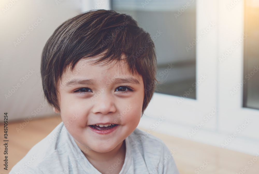 Portrait of happy little boy looking at camera with smiling face, Head shot Healthy child playing in kid room, Positive kid relaxing at home on weekend during spring or summer time Portrait of happy little boy looking at camera with smiling face, Head shot Healthy child playing in kid room, Positive kid relaxing at home on weekend during spring or summer time