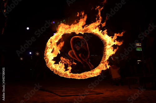 Mężczyzna skaczący przez ognisty krąg podczas full moon party na wyspie Phi Phi w Tajlandii