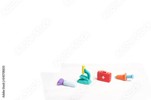 pile of eraser medical cross sigh bag ,otoscope,microscope and syringe on blur background with copy space