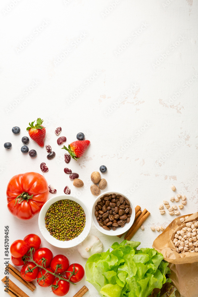 Fresh vegetarian food ingredients on white surface Fresh vegetarian food ingredients on white surface