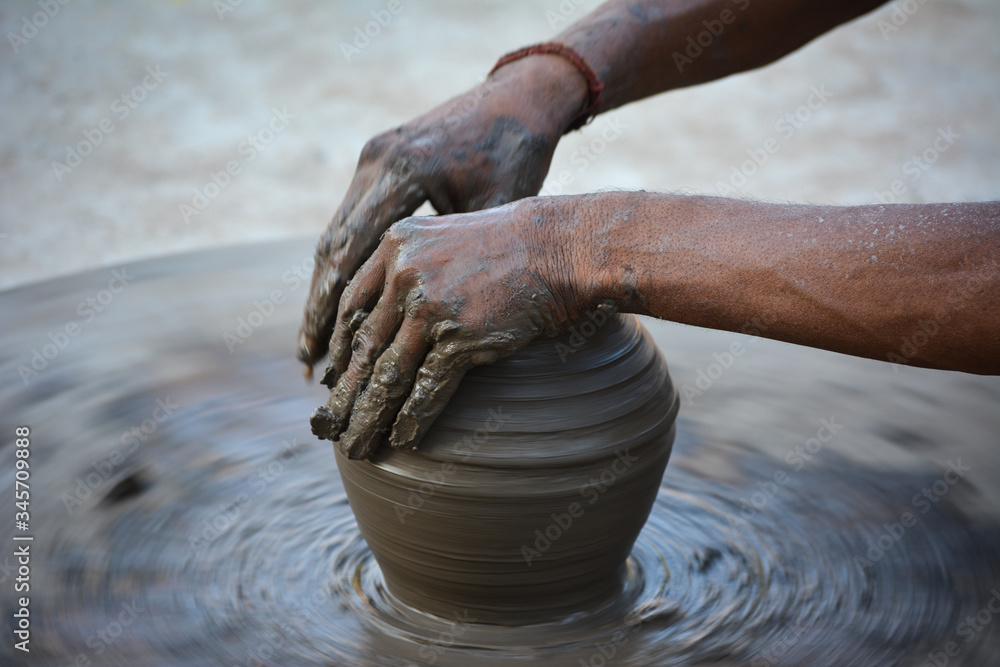Hands working on pottery wheel and making a pot Hands working on pottery wheel and making a pot