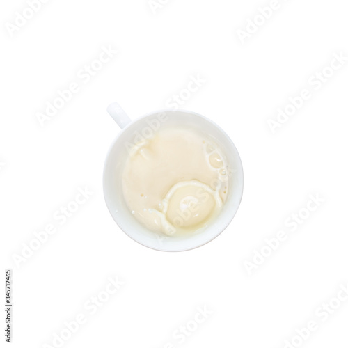 Milk splash from a cup isolated on white background, top view