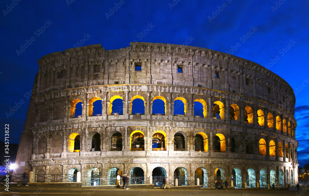 Colosseum illuminated night view, Rome, Italy. Colosseo, Roma.  Tourists with motion blur.