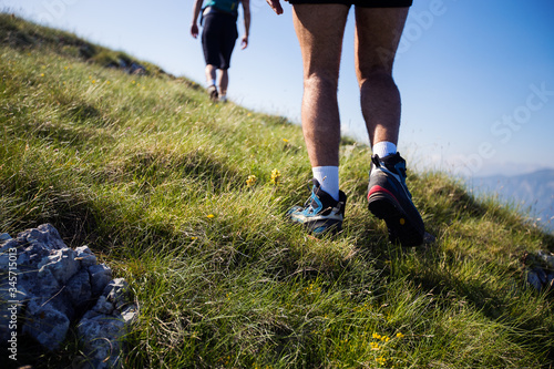 Low rear view of hikers walking up mountain