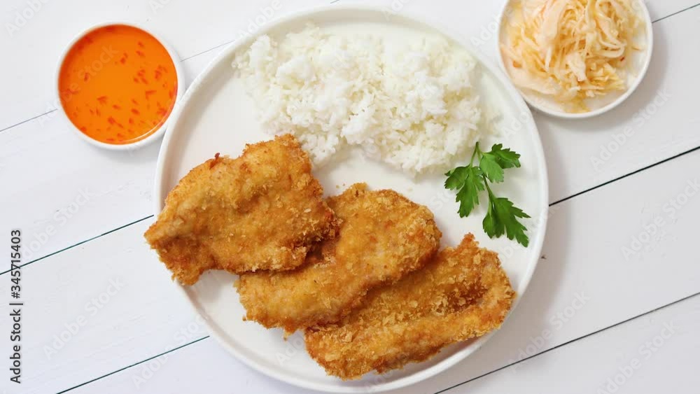 Crispy chicken fried in breadcrumbs served with rice. View from the top on white wooden background Crispy chicken fried in breadcrumbs served with rice. View from the top on white wooden background
