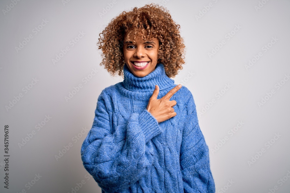 Young beautiful african american woman wearing turtleneck sweater over white background cheerful with a smile on face pointing with hand and finger up to the side with happy and natural expression Young beautiful african american woman wearing turtleneck sweater over white background cheerful with a smile on face pointing with hand and finger up to the side with happy and natural expression