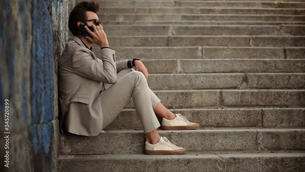 Businessman Sitting On Steps And Talking On Mobile Phone.Freelancer Internet Online Meeting Webinar And Calling.Man Freelance With Smartphone Outdoors.Businessman With Phone On Steps Remote Working. Businessman Sitting On Steps And Talking On Mobile Phone.Freelancer Internet Online Meeting Webinar And Calling.Man Freelance With Smartphone Outdoors.Businessman With Phone On Steps Remote Working.
