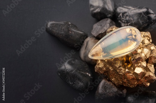 Photos Drop of moonstone on golden friends on a dark background.