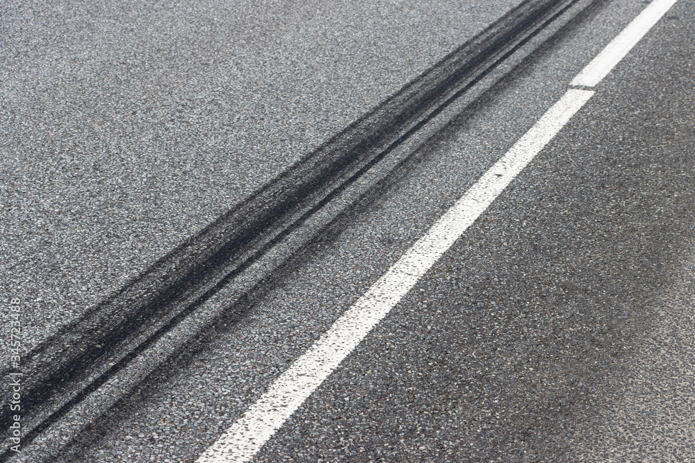 Fototapeta premium A burned rubber tire track on an asphalt road.