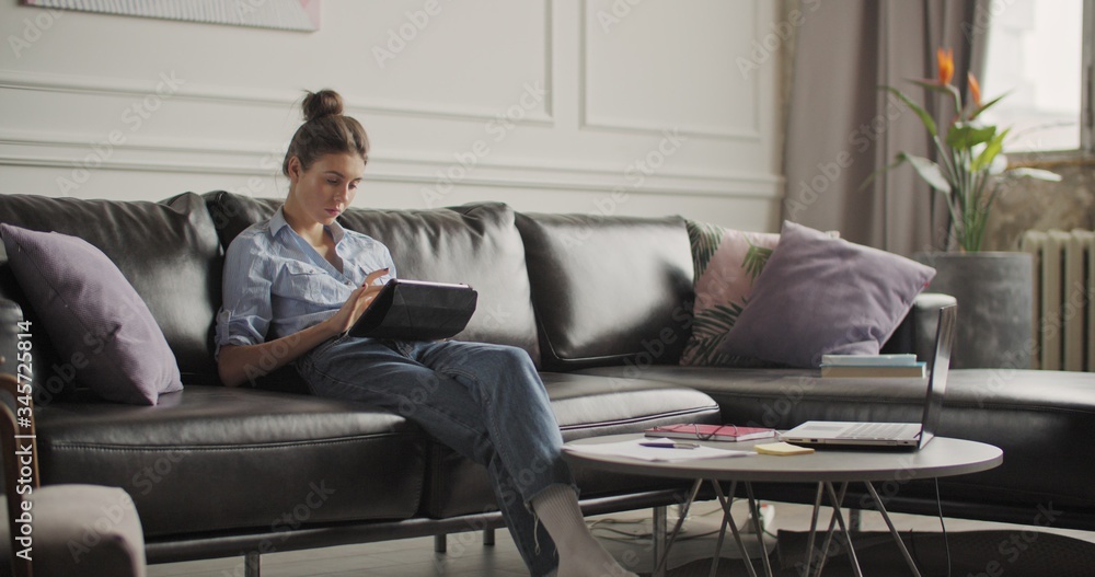 Young woman using digital tablet computer in home