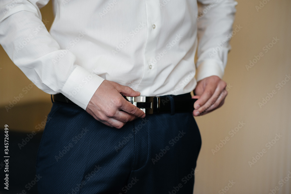 Stylish young man buttoning the cuff links on the sleeves. Style Stylish young man buttoning the cuff links on the sleeves. Style