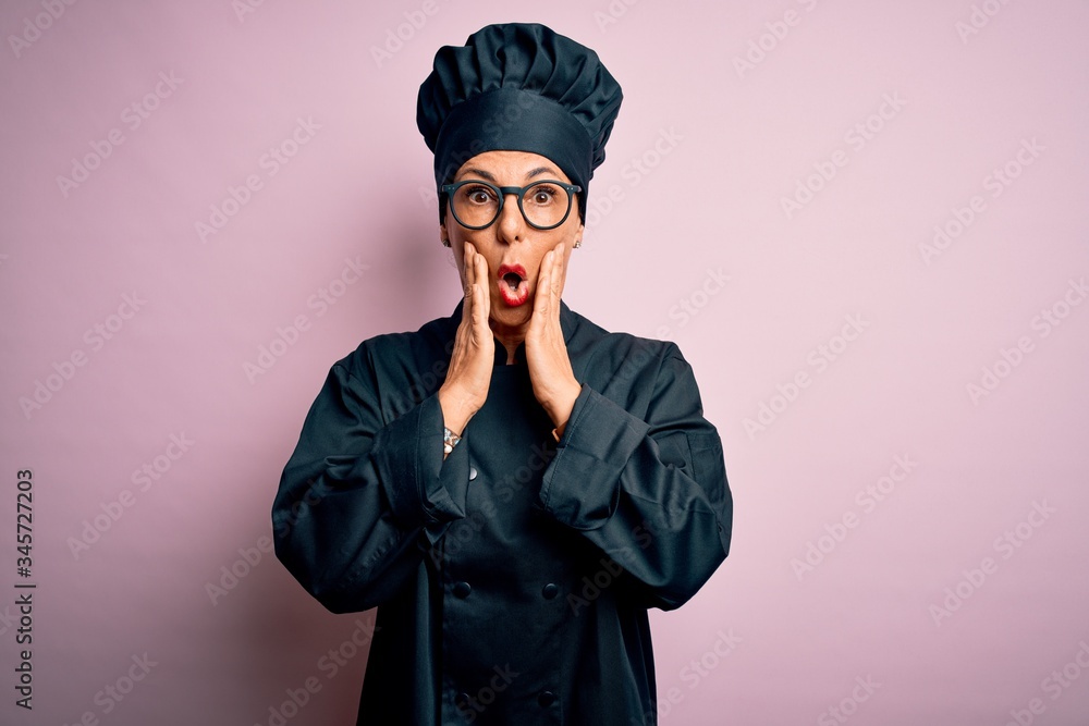 Middle age brunette chef woman wearing cooker uniform and hat over isolated pink background afraid and shocked, surprise and amazed expression with hands on face Middle age brunette chef woman wearing cooker uniform and hat over isolated pink background afraid and shocked, surprise and amazed expression with hands on face
