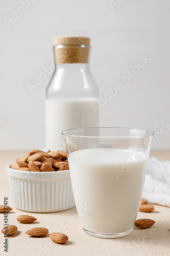 Almond milk in a glass and a glass bottle.